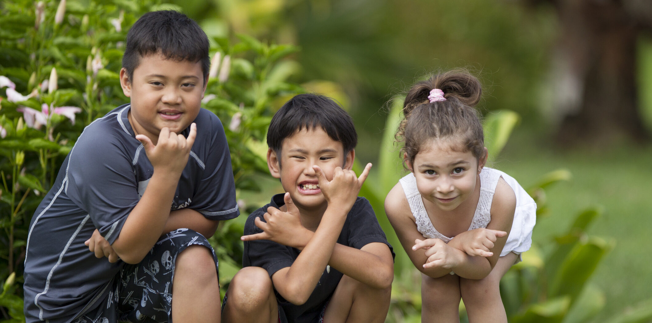 Three children give hang loose hand sign