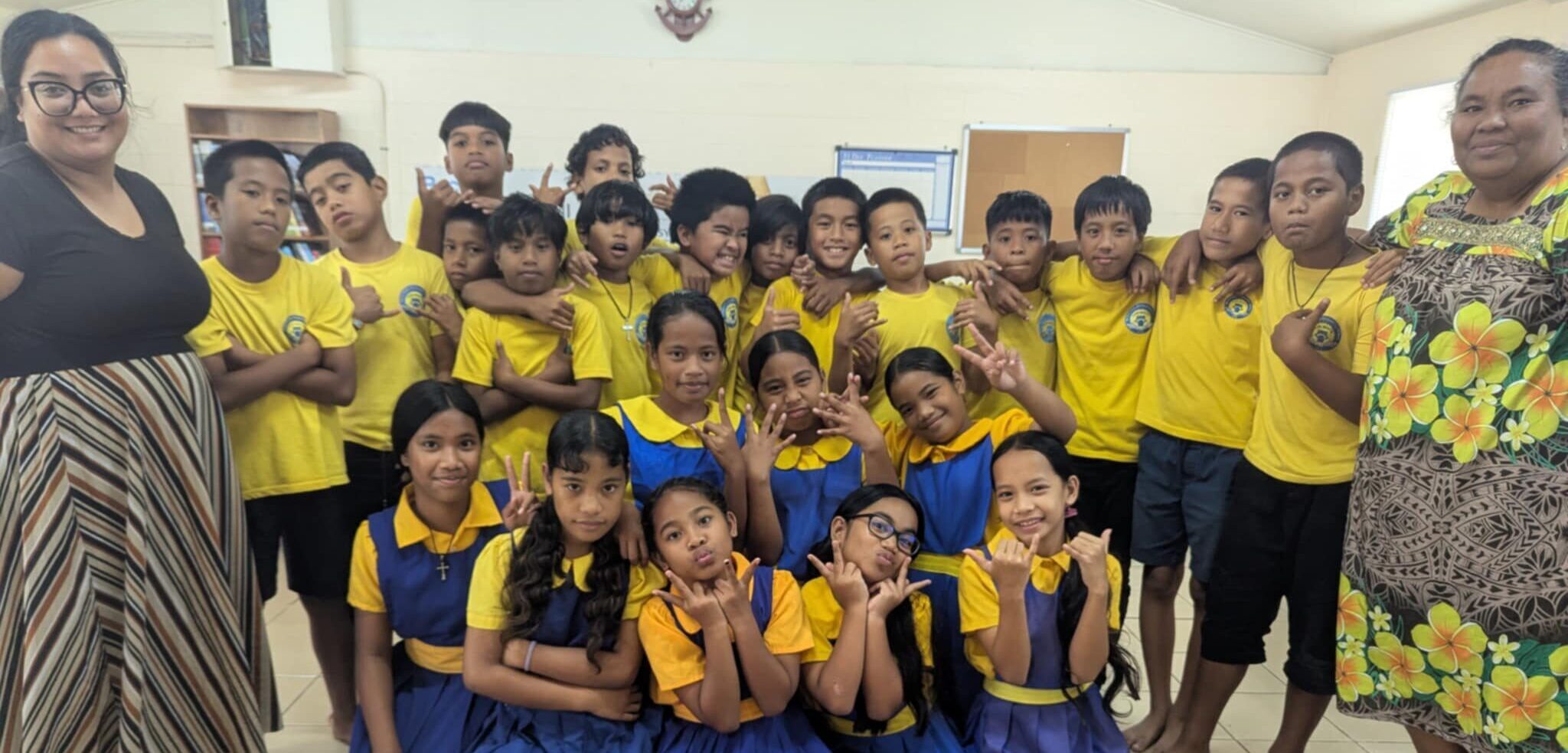 A class of students centered between two teachers.
